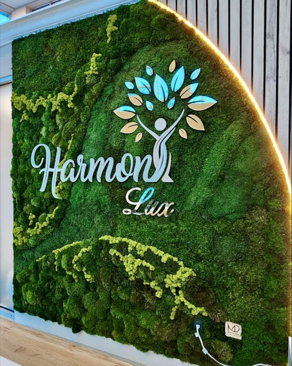Moss wall with 'Harmon Lux' logo in a modern indoor setting