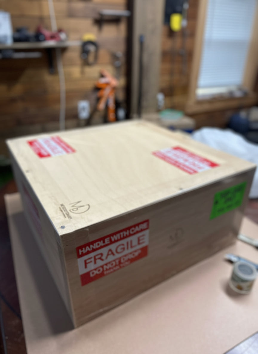 Fragile cardboard box with warning labels on a wooden surface