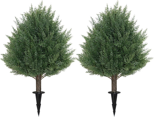 Two artificial trees with stakes on a white background