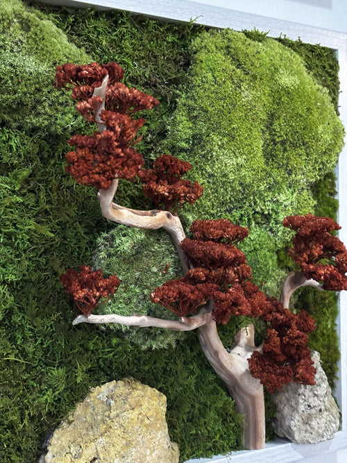 Artificial bonsai trees with red leaves on a green moss background